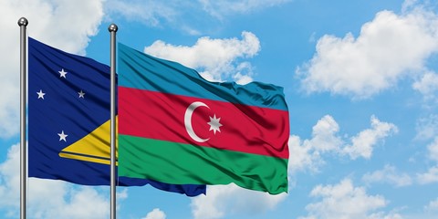 Tokelau and Azerbaijan flag waving in the wind against white cloudy blue sky together. Diplomacy concept, international relations.