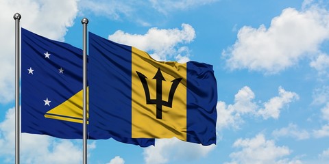 Tokelau and Barbados flag waving in the wind against white cloudy blue sky together. Diplomacy concept, international relations.