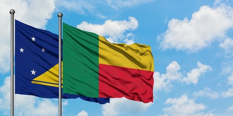 Tokelau and Benin flag waving in the wind against white cloudy blue sky together. Diplomacy concept, international relations.