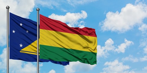 Tokelau and Bolivia flag waving in the wind against white cloudy blue sky together. Diplomacy concept, international relations.