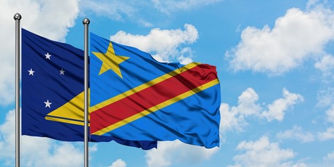 Tokelau and Congo flag waving in the wind against white cloudy blue sky together. Diplomacy concept, international relations.