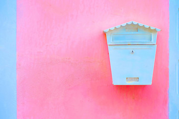 White mailbox or letterbox on a pink wall.