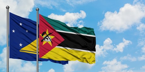 Tokelau and Mozambique flag waving in the wind against white cloudy blue sky together. Diplomacy concept, international relations.