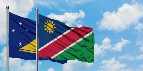 Tokelau and Namibia flag waving in the wind against white cloudy blue sky together. Diplomacy concept, international relations.