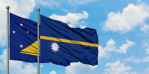 Tokelau and Nauru flag waving in the wind against white cloudy blue sky together. Diplomacy concept, international relations.