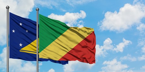 Tokelau and Republic Of The Congo flag waving in the wind against white cloudy blue sky together. Diplomacy concept, international relations.