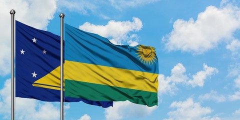 Tokelau and Rwanda flag waving in the wind against white cloudy blue sky together. Diplomacy concept, international relations.