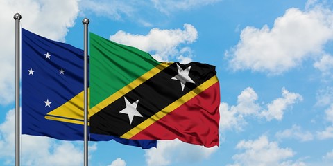 Tokelau and Saint Kitts And Nevis flag waving in the wind against white cloudy blue sky together. Diplomacy concept, international relations.