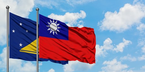 Tokelau and Taiwan flag waving in the wind against white cloudy blue sky together. Diplomacy concept, international relations.