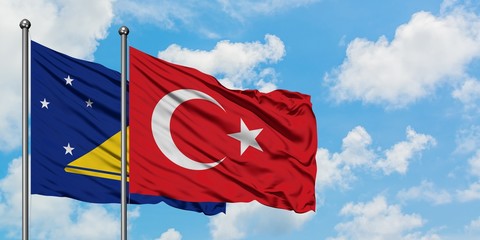 Tokelau and Turkey flag waving in the wind against white cloudy blue sky together. Diplomacy concept, international relations.