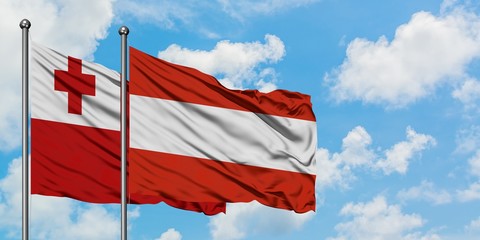 Tonga and Austria flag waving in the wind against white cloudy blue sky together. Diplomacy concept, international relations.