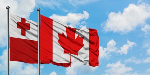 Tonga and Canada flag waving in the wind against white cloudy blue sky together. Diplomacy concept, international relations.