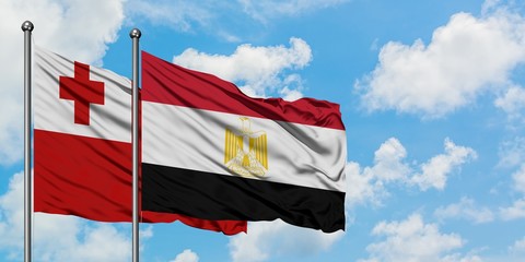 Tonga and Egypt flag waving in the wind against white cloudy blue sky together. Diplomacy concept, international relations.