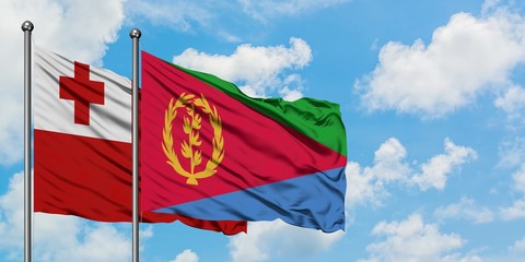 Tonga and Eritrea flag waving in the wind against white cloudy blue sky together. Diplomacy concept, international relations.