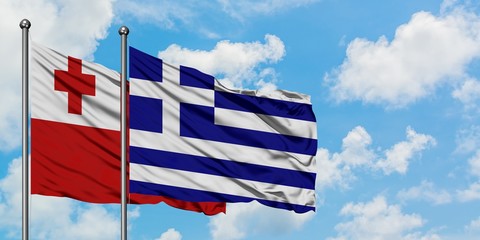 Tonga and Greece flag waving in the wind against white cloudy blue sky together. Diplomacy concept, international relations.