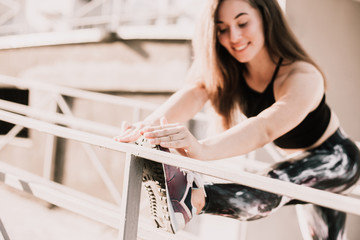 Beautiful sport fitness girl in sportswear doing fitness exercise in the street ,outdoor sports. Urban style.