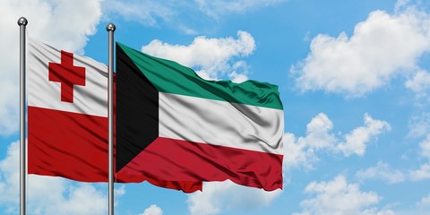 Tonga and Kuwait flag waving in the wind against white cloudy blue sky together. Diplomacy concept, international relations.
