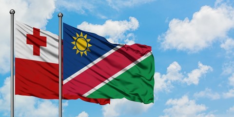 Tonga and Namibia flag waving in the wind against white cloudy blue sky together. Diplomacy concept, international relations.