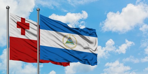Tonga and Nicaragua flag waving in the wind against white cloudy blue sky together. Diplomacy concept, international relations.
