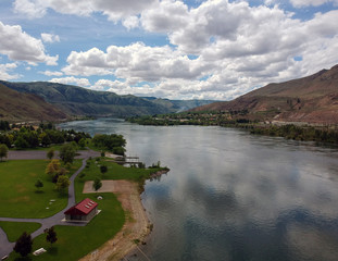 Remarkable Aerial Photography of Beebe Bridge Park with a clear blue sky and bright cumulus clouds in a craggy mountain setting with the Columbia River outside Chelan Washington.