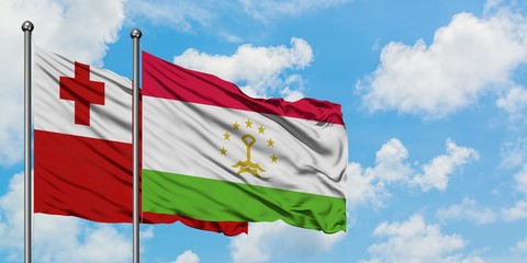 Tonga and Tajikistan flag waving in the wind against white cloudy blue sky together. Diplomacy concept, international relations.