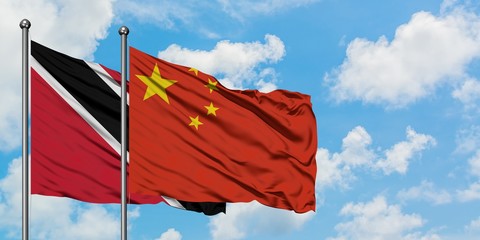 Trinidad And Tobago and China flag waving in the wind against white cloudy blue sky together. Diplomacy concept, international relations.