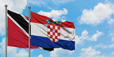 Trinidad And Tobago and Croatia flag waving in the wind against white cloudy blue sky together....