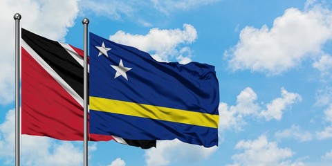 Trinidad And Tobago and Curacao flag waving in the wind against white cloudy blue sky together. Diplomacy concept, international relations.