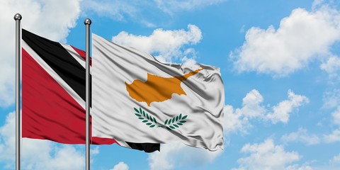 Trinidad And Tobago and Cyprus flag waving in the wind against white cloudy blue sky together. Diplomacy concept, international relations.
