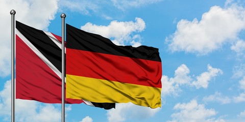 Trinidad And Tobago and Germany flag waving in the wind against white cloudy blue sky together. Diplomacy concept, international relations.