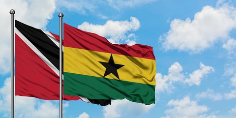 Trinidad And Tobago and Ghana flag waving in the wind against white cloudy blue sky together. Diplomacy concept, international relations.