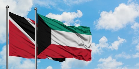 Trinidad And Tobago and Kuwait flag waving in the wind against white cloudy blue sky together. Diplomacy concept, international relations.
