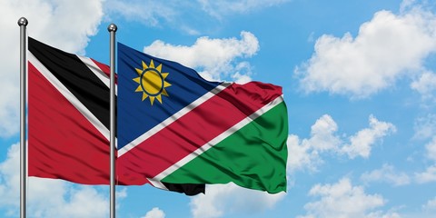 Trinidad And Tobago and Namibia flag waving in the wind against white cloudy blue sky together. Diplomacy concept, international relations.