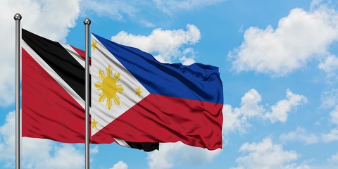 Trinidad And Tobago and Philippines flag waving in the wind against white cloudy blue sky together. Diplomacy concept, international relations.