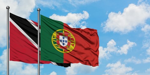 Trinidad And Tobago and Portugal flag waving in the wind against white cloudy blue sky together. Diplomacy concept, international relations.