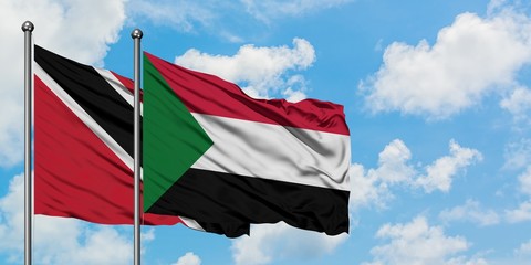 Trinidad And Tobago and Sudan flag waving in the wind against white cloudy blue sky together. Diplomacy concept, international relations.