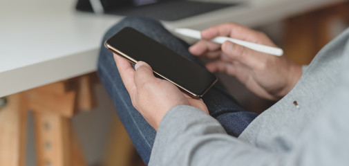 Close-up view of young professional businessman using smartphone