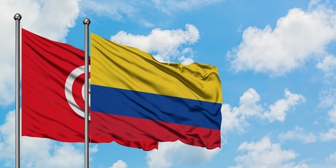 Tunisia and Colombia flag waving in the wind against white cloudy blue sky together. Diplomacy concept, international relations.