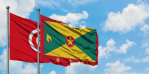 Tunisia and Grenada flag waving in the wind against white cloudy blue sky together. Diplomacy concept, international relations.