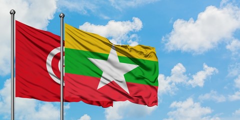 Tunisia and Myanmar flag waving in the wind against white cloudy blue sky together. Diplomacy concept, international relations.