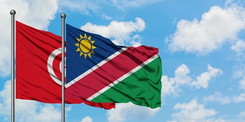 Tunisia and Namibia flag waving in the wind against white cloudy blue sky together. Diplomacy concept, international relations.