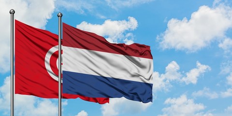 Tunisia and Netherlands flag waving in the wind against white cloudy blue sky together. Diplomacy concept, international relations.