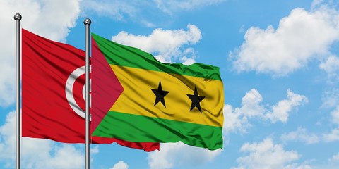 Tunisia and Sao Tome And Principe flag waving in the wind against white cloudy blue sky together. Diplomacy concept, international relations.