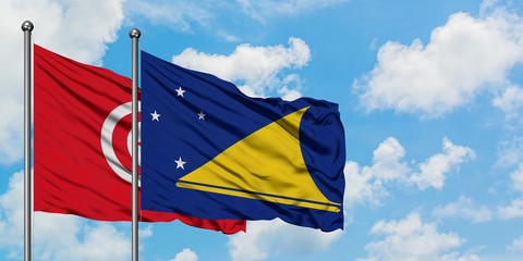 Tunisia and Tokelau flag waving in the wind against white cloudy blue sky together. Diplomacy concept, international relations.