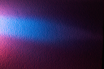 Blue horizontal ray of light cuts pink texture background