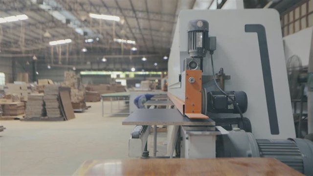 Edgebander machine. People work on edgebanding machine. Single sided automatic edge bander on factory.