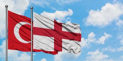 Turkey and England flag waving in the wind against white cloudy blue sky together. Diplomacy concept, international relations.