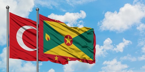 Turkey and Grenada flag waving in the wind against white cloudy blue sky together. Diplomacy concept, international relations.