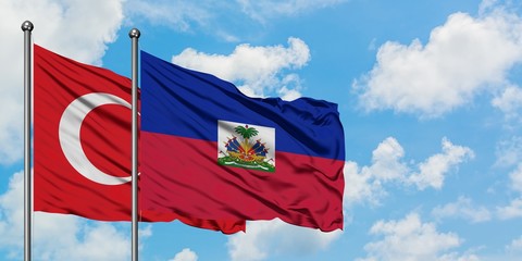 Turkey and Haiti flag waving in the wind against white cloudy blue sky together. Diplomacy concept, international relations.