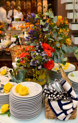 table with flowers,  buffet table setting, party table setting, table setting, stacked dishes, porcelain plates	